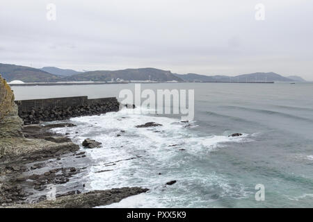 Un paesaggio di alte scogliere bagnate su un mare agitato durante un nuvoloso giorno di pioggia da Paseo de la Galea nella città di Getxo, nei Paesi Baschi, Spagna Foto Stock