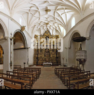 La navata principale del romanico Colegiata de Santa Maria la Mayor chiesa in un Alquezar, Spagna, con il barocco golden pala, banchi e archi Foto Stock