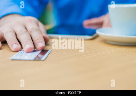 Le mani di uomo dando la scheda di plastica al cameriere per pagare l'ordine. Uomo d'affari di pagare con una carta di credito o di debito Foto Stock