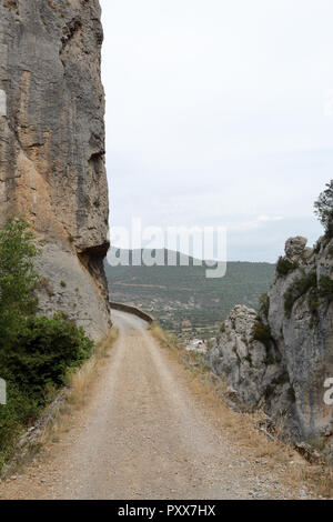 Un percorso che passa accanto a una scarpata in Mallos de Riglos, nei Pirenei, nella regione di Aragona, Spagna Foto Stock