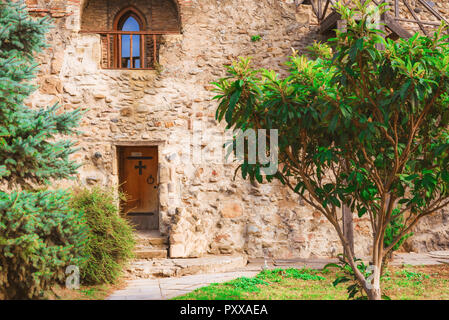 Il cantiere del monastero antico con alberi e una porta in una parete Foto Stock