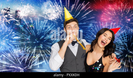 Coppia felice con party soffianti divertendosi Foto Stock