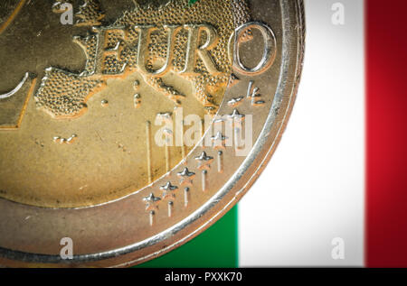 2 monete in euro con una bandiera sfocata dell Italia sullo sfondo. Foto Stock