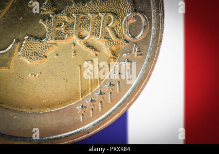 2 monete in euro con una offuscata bandiera della Francia sullo sfondo. Foto Stock