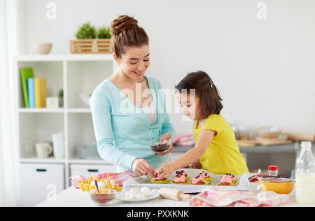 Felice madre e figlia tortini di cottura a casa Foto Stock