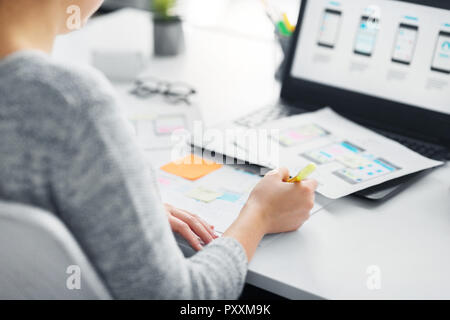 Web designer che lavora su interfaccia utente in ufficio Foto Stock