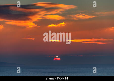 Il sole sta per scomparire dietro qualche nuvola-cover Foto Stock