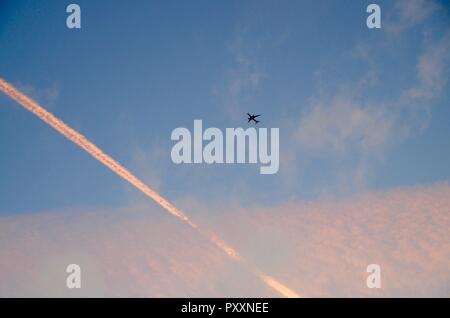 Contrails colorato di rosa dal tramonto a sinistra su Londra Inghilterra Foto Stock