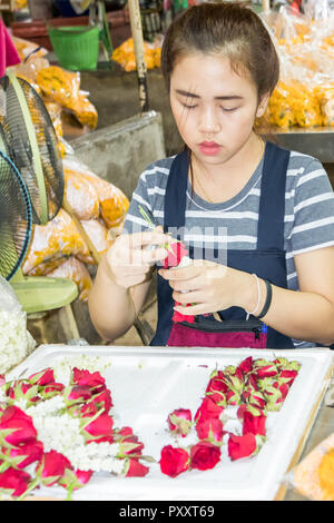 Bangkok, Tailandia - 26 Settembre 2018: una ragazza rende ghirlande nel Pak Khlong Talat il mercato dei fiori. Molti ghirlande sono fatte qui. Foto Stock