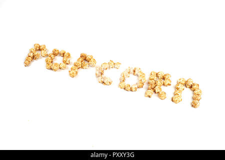 La parola POPKORN è stabilito da pezzi di caramello popcorn su uno sfondo bianco. Foto Stock