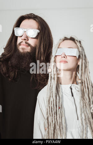 Il futuristico coppia giovane con sfumature metalliche cercando Foto Stock