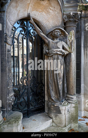 La figura scolpita di una donna che sta al di fuori di una tomba nel cimitero di Passy, Paris, Francia. Foto Stock