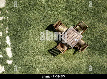 Blick von oben auf Gartenstuehle und Tisch auf Rasun Foto Stock