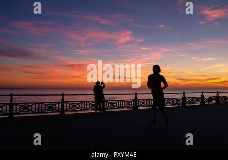 Brighton, Regno Unito. 24 ott 2018. Un runner passa da come il sole tramonta lungo la Brighton e Hove lungomare questa sera dopo un altro giorno caldo e soleggiato sulla costa sud Credito: Simon Dack/Alamy Live News Foto Stock