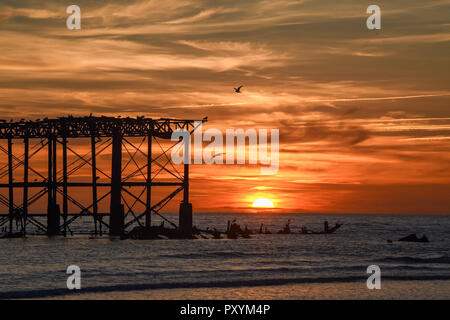 Brighton, Regno Unito. 24 ott 2018. Il sole tramonta dal Molo Ovest di Brighton questa sera dopo un altro giorno caldo e soleggiato sulla costa sud Credito: Simon Dack/Alamy Live News Foto Stock