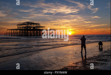 Brighton, Regno Unito. 24 ott 2018. Il sole tramonta dal Molo Ovest di Brighton questa sera dopo un altro giorno caldo e soleggiato sulla costa sud Credito: Simon Dack/Alamy Live News Foto Stock