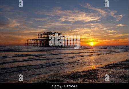 Brighton, Regno Unito. 24 ott 2018. Il sole tramonta dal Molo Ovest di Brighton questa sera dopo un altro giorno caldo e soleggiato sulla costa sud Credito: Simon Dack/Alamy Live News Foto Stock