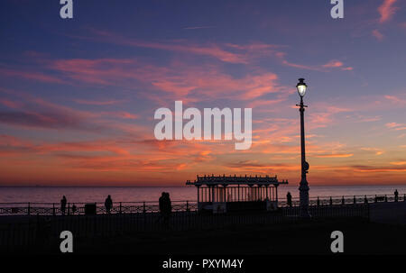 Brighton, Regno Unito. 24 ott 2018. Il sole tramonta ad ovest lungo molo di Brighton e Hove lungomare questa sera dopo un altro giorno caldo e soleggiato sulla costa sud Credito: Simon Dack/Alamy Live News Foto Stock