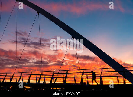 Stockton on Tees, a nord-est dell' Inghilterra, Regno Unito. 24 ott 2018. Meteo: le persone che attraversano la Infinity ponte sopra il Fiume Tees in Stockton sono trattati per un tramonto spettacolare mercoledì. Credito: ALAN DAWSON/Alamy Live News Foto Stock