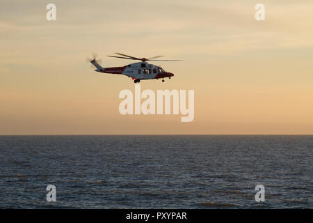 Porthcawl, South Wales, Regno Unito. 24 ott 2018. Regno Unito: meteo il RNLI e HM Guardguard condotta pratica esercitazioni di salvataggio al largo di questa sera. Credito: Andrew Bartlett/Alamy Live News Foto Stock