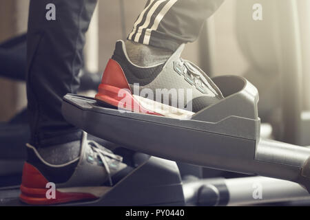 Primo piano dell'uomo piedi facendo esercizi cardio-training in esecuzione Palestra Fitness in formazione legale Club Vita sana nozione Foto Stock