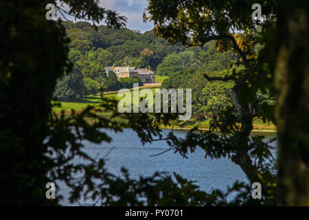 Penrose casa visto attraverso gli alberi all'Loe o Loe Pool, Cornwall il più grande lago naturale, vicino a Loe Bar, vicino a Helston, Cornwall, Regno Unito Foto Stock