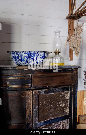 Antiche porcellane blu e bianco lavabo & il vecchio olio lampada sul tavolo di legno in interni di casa a Chestnut Square villaggio storico, McKinney Texas. Foto Stock