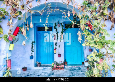 Tipica facciata di colore blu con le antiche porte decorate con vasi a Chefchaouen, Marocco Foto Stock