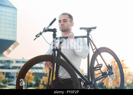 Imprenditore portando la sua moto andare al piano di sopra Foto Stock