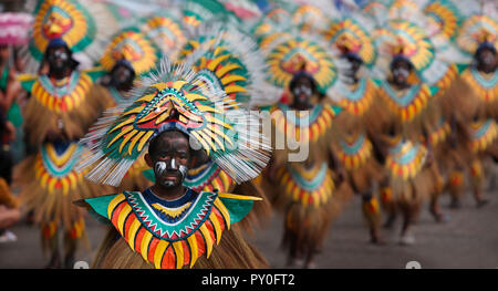 Ragazzo con faccia dipinta in costume tribale davanti a un vasto gruppo di persone in costumi tribali durante Ati Atihan Festival, Kalibo, Aklan, Panay Island, Filippine Foto Stock