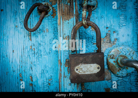 Vecchio lucchetto arrugginito made in Cina di blocco blu sulla porta di legno Foto Stock