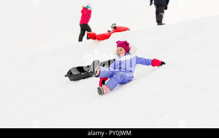 I bambini con slittini sulla collina di neve in inverno Foto Stock