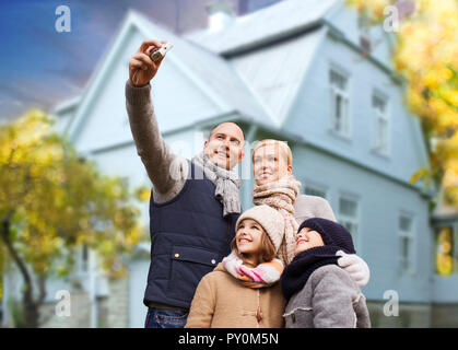 Famiglia prende autunno selfie dalla telecamera su house Foto Stock