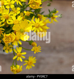 Bel giallo bouquet di fiori si erge su uno sfondo di legno, copia dello spazio. Foto Stock