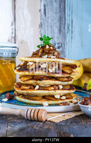 Il cioccolato-riempito pancake con banane caramellate, miele e nocciole Foto Stock