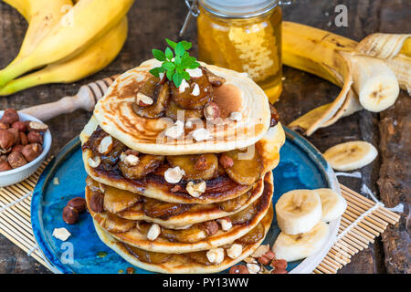 Il cioccolato-riempito pancake con banane caramellate, miele e nocciole Foto Stock