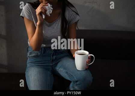Vista ritagliata di turbare la donna azienda igienico e tazza di caffè Foto Stock