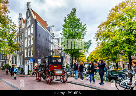 Cavallo e Carrozza che trasportano i turisti oltre il ponte intersezione del Bloemgracht e Prinsengracht canali nel quartiere Jordaan di Amsterdam Foto Stock