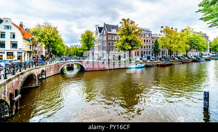 Canal Boat entrando nel canale Keizersgracht dal Leliegracht canale nel centro storico di Amsterdam in Neteherlands Foto Stock