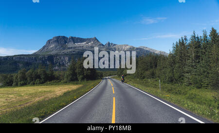 N bike ciclista a cavallo, lungo una strada di campagna; chiara giornata estiva, Norvegia imballaggio bici Foto Stock