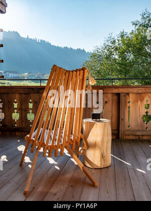 Chiudere l immagine della sedia in legno sul balcone nel paesaggio alpino Foto Stock