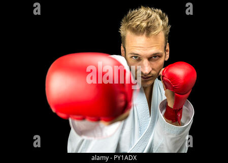 Vista frontale dei giovani kick boxer fighter isolate su sfondo nero. Foto Stock