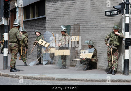 Esercito britannico i soldati in sommossa ingranaggio su un angolo di strada in Belfast City Centre, 1972 durante i guai, Irlanda del Nord in conflitto Foto Stock