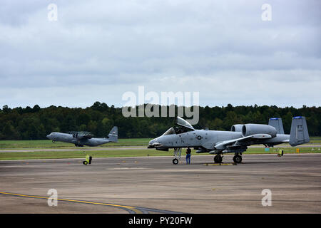 Un A-10 Thunderbolt II assegnato a Moody Air Force Base, Ga.,, taxi ad un posto parcheggio dopo lo sbarco a Little Rock Air Force Base, arca come una C-130J dal xix Airlift Wing decolla, Ottobre 9, 2018. Aeromobili e il personale sono stati evacuati come una precauzione per proteggerli dall uragano Michael. L'A-10, comunemente denominato Warthog, ha una eccellente manovrabilità a bassa velocità dell'aria e di altitudine ed è estremamente precise e resiliente delle armi-piattaforma di consegna. Il velivolo può bighellonare nei pressi di zone di battaglia per lunghi periodi di tempo e di operare in soffitti bassi e le condizioni di visibilità. Il Foto Stock