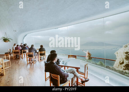 Gruppo di turisti che si godono di vista isola di La Graciosa attraverso le finestre del Mirador del Rio viewpoint a Lanzarote, Mirador del Rio, Isole Canarie, Spagna Foto Stock