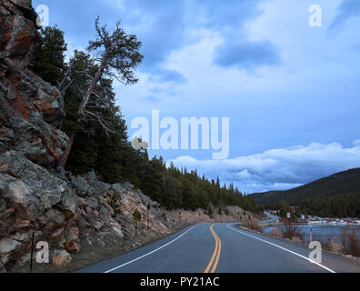 Sera Squaw Pass Road con una inclinazione albero accanto al lago di Echo sul modo di Mount Evans in Colorado, STATI UNITI D'AMERICA Foto Stock