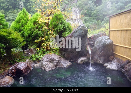 La cottura a vapore caldo rotenburo (bagno esterno) sotto la pioggia, Sakamaki Onsen Ryokan, Prefettura di Nagano, Matsumoto, Honshu, Giappone. N. PR Foto Stock