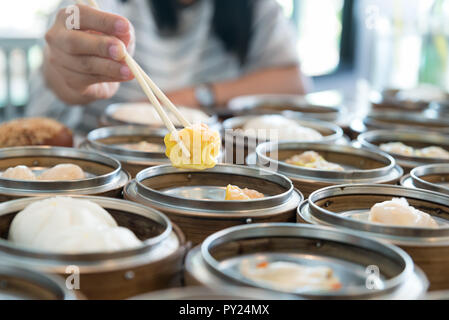 Cinese gnocco in streaming nel cestello di bambù sul tavolo nel ristorante cinese. Foto Stock