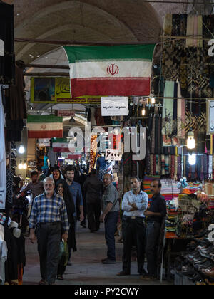 ISFAHAN, IRAN - Agosto 8, 2018: Street di Isfahan bazar con una bandiera iraniana appeso in un vicolo coperto del mercato. Simbolo dell'arco Persiano Foto Stock