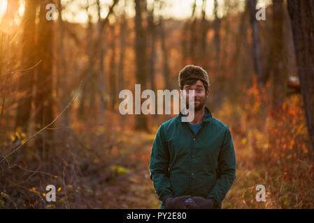 Ritratto di un uomo in piedi nel bosco tirando facce buffe, Stati Uniti Foto Stock